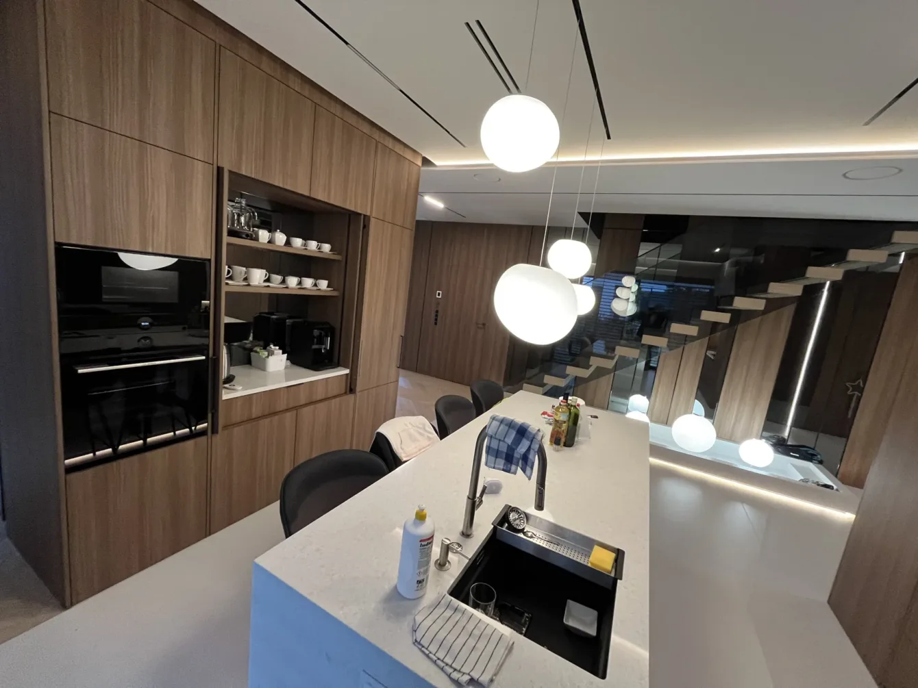 Kuchnia z wyspą w apartamencie, fronty fornirowane orzechem, realizacja Modern Line