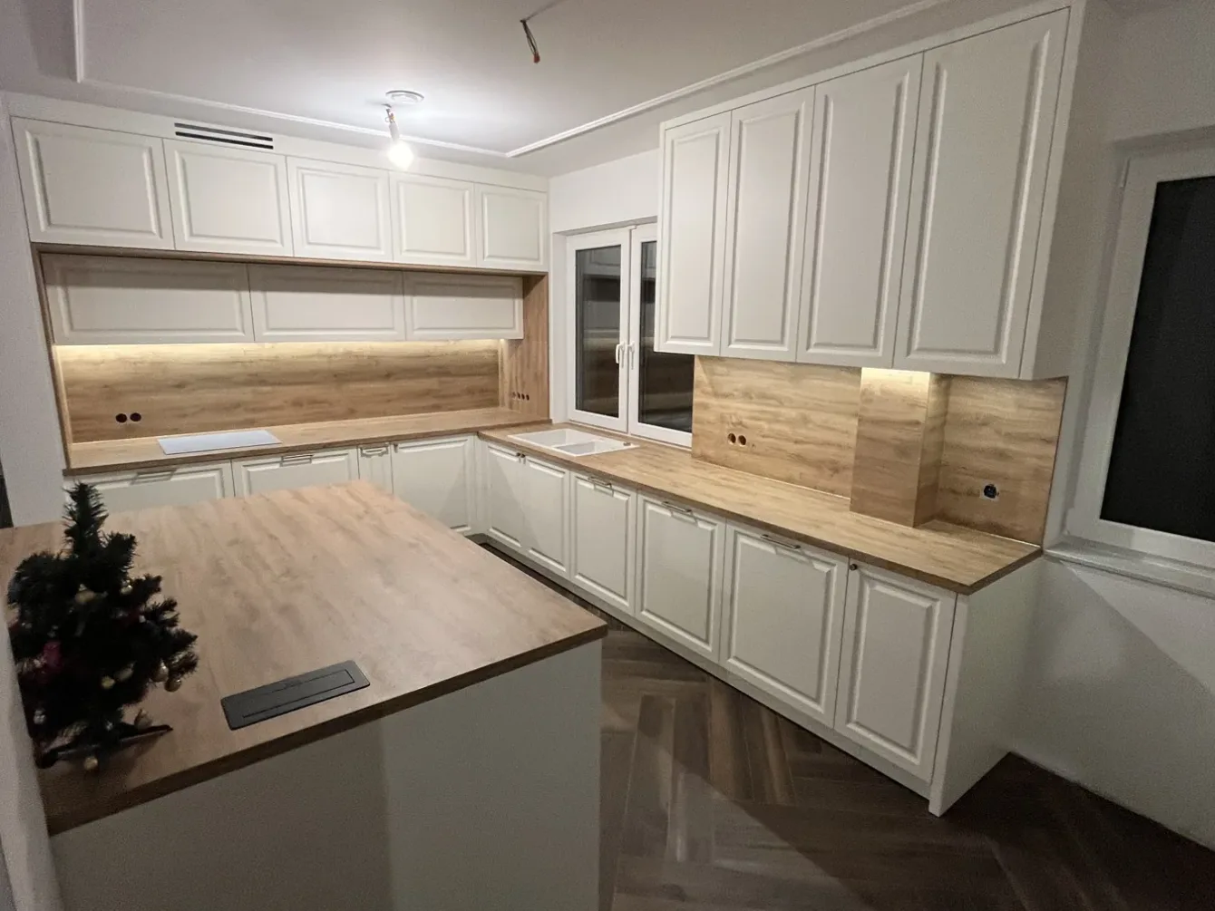 Kuchnia z wyspą i zabudową w dekorze drewna, realizacja Modern Line