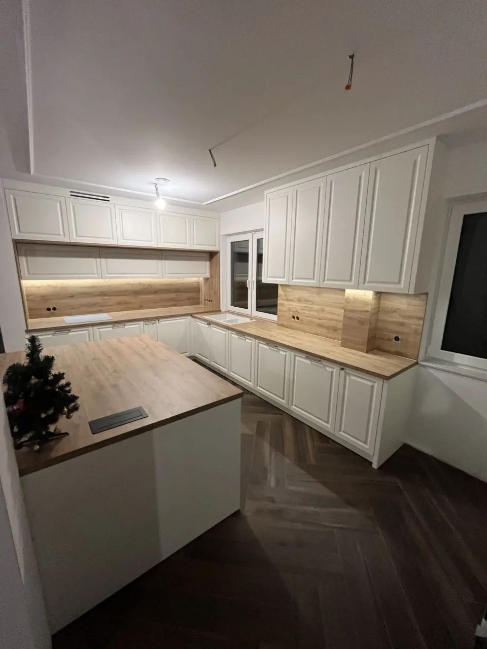 Kuchnia z wyspą i zabudową w dekorze drewna, realizacja Modern Line