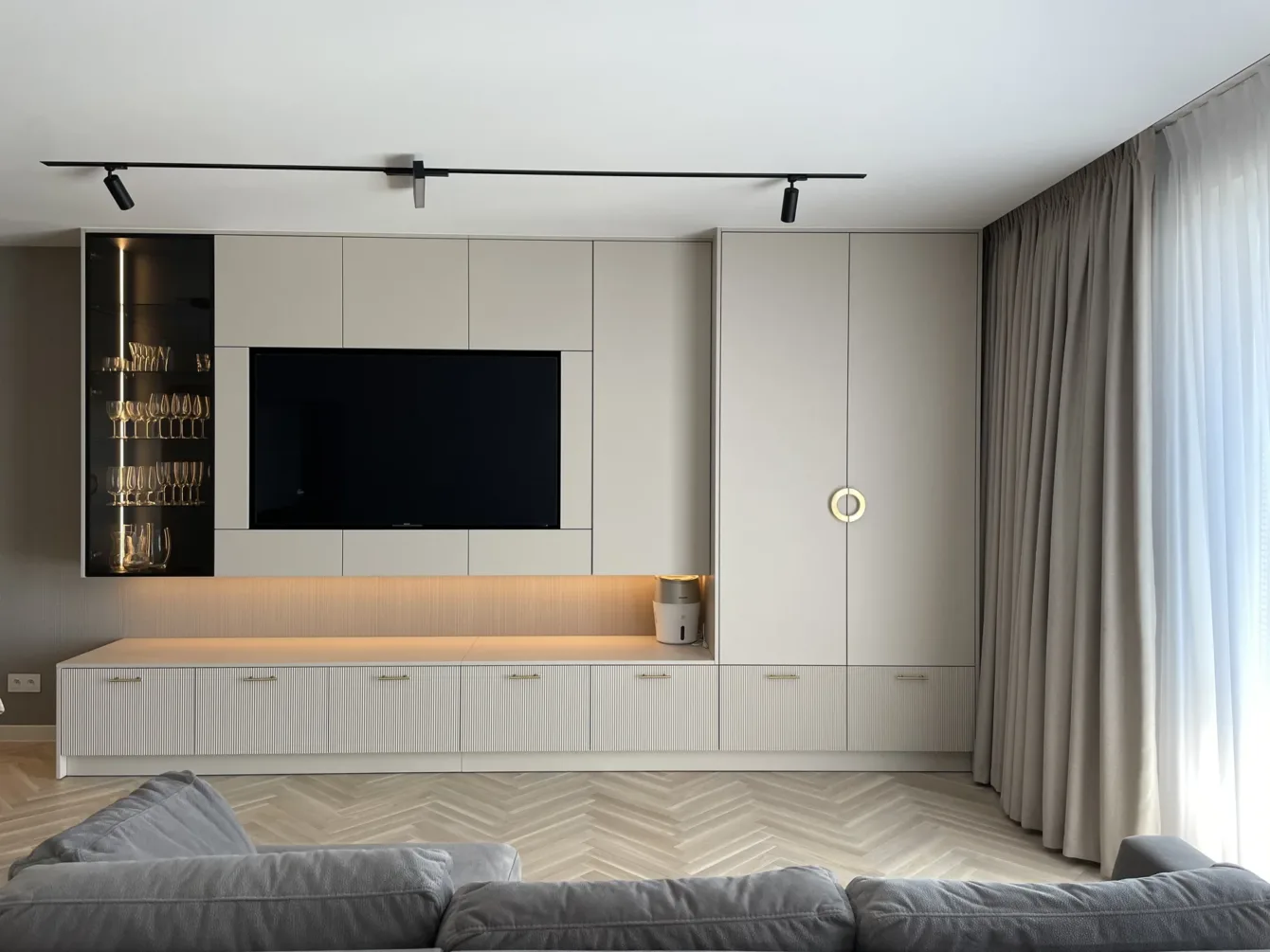 Zabudowa ściany TV z ryflowanymi frontami i podświetleniem, realizacja Modern Line